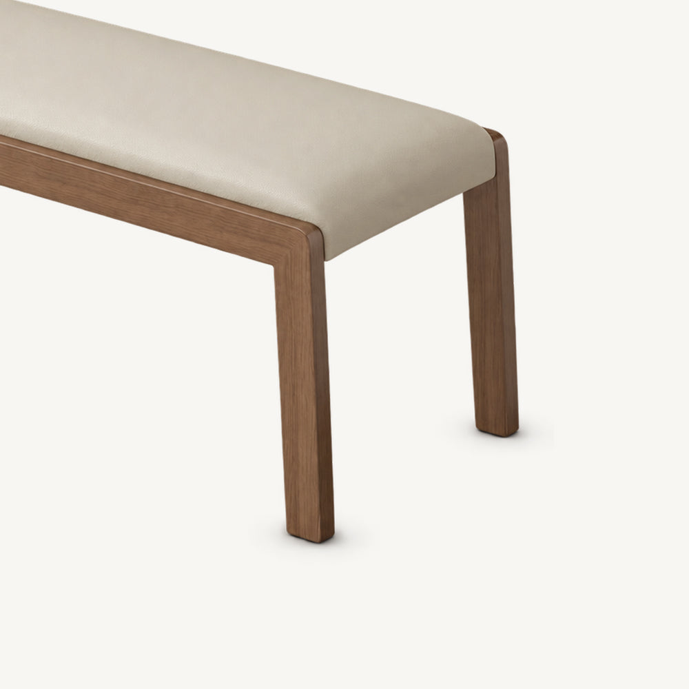 Close-up of the cream bench cushion and right corner of its brown frame.