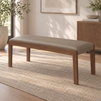 Angled room view of the taupe upholstered bench with a slim wood-tone frame.