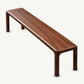 Brown wood-grain bench with a long narrow seat, rounded edges and four straight slim legs.