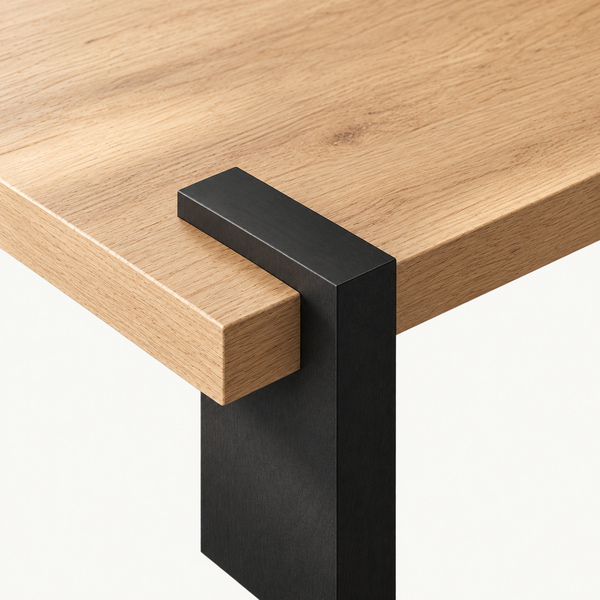 Overhead detail of a black support wrapping over the light wood-grain square tabletop edge.