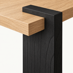 Close-up of the coffee table's black block leg and projecting light wood-grain tabletop corner.
