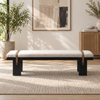 Front view of the cream-cushioned black bench with two brown decorative straps.