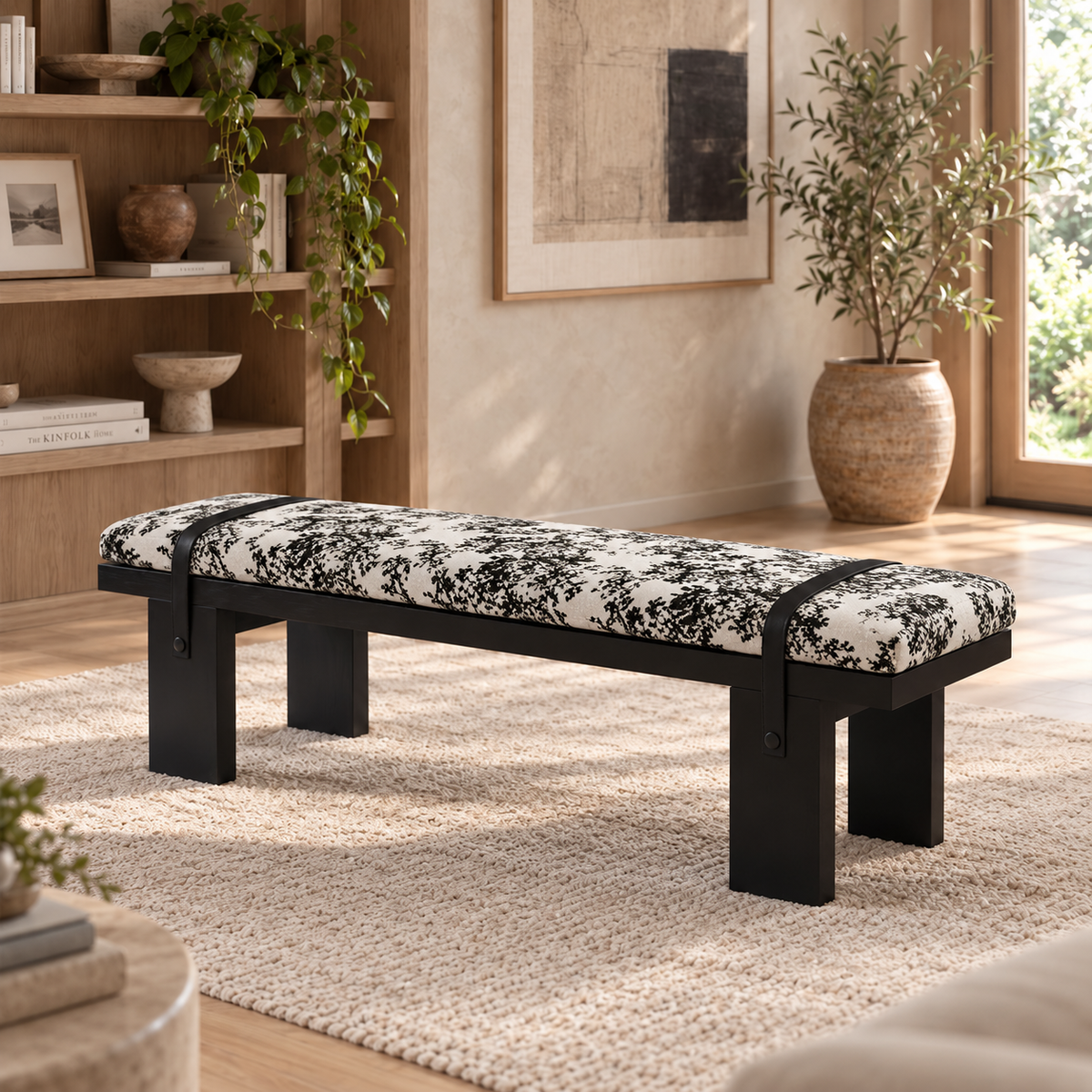 Black-framed bench with black-and-white patterned upholstery and dark straps in a bright room.