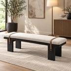 Angled room view of the long cream bench cushion above a black frame and broad legs.