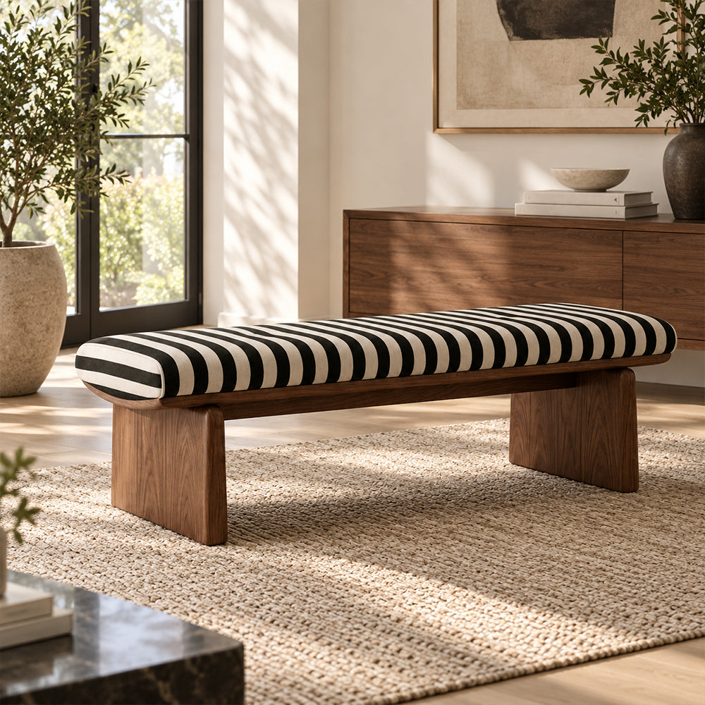 Black-and-cream striped bench with a brown wood-tone frame on a pale woven rug.