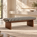 Bench with black-and-cream striped upholstery on a brown frame with broad panel legs.