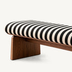 Close-up of the bench's black-and-cream striped cushion above a brown panel support.