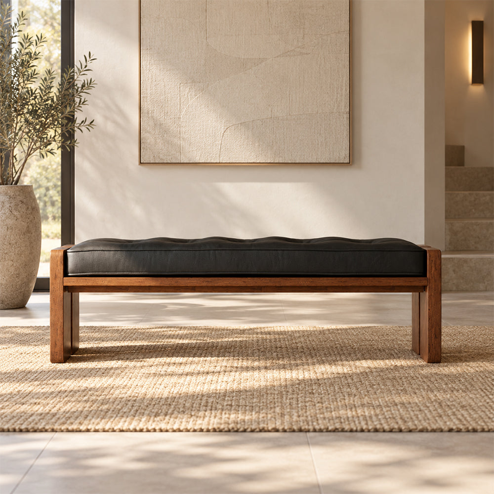 Front view of the black cushioned bench with a brown frame and broad panel legs.
