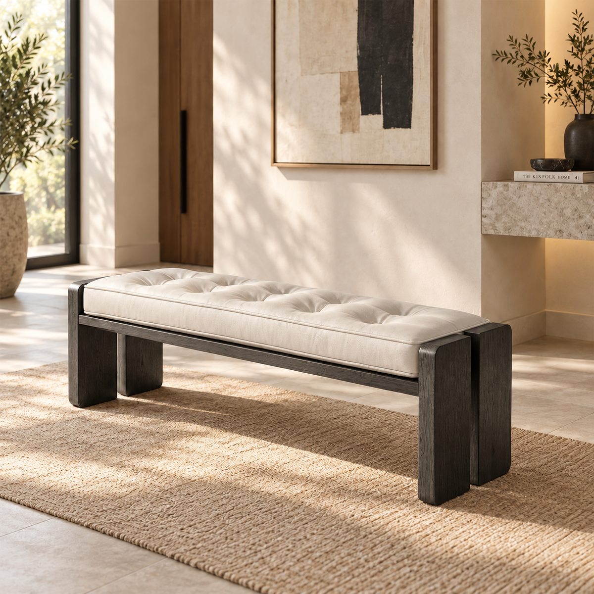 Cream tufted bench with a dark frame and split-panel legs in a sunlit entryway.