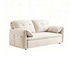 Cream sofa bed in sofa form with tufted back cushions, arm pillows and gold-tone feet on a white background.