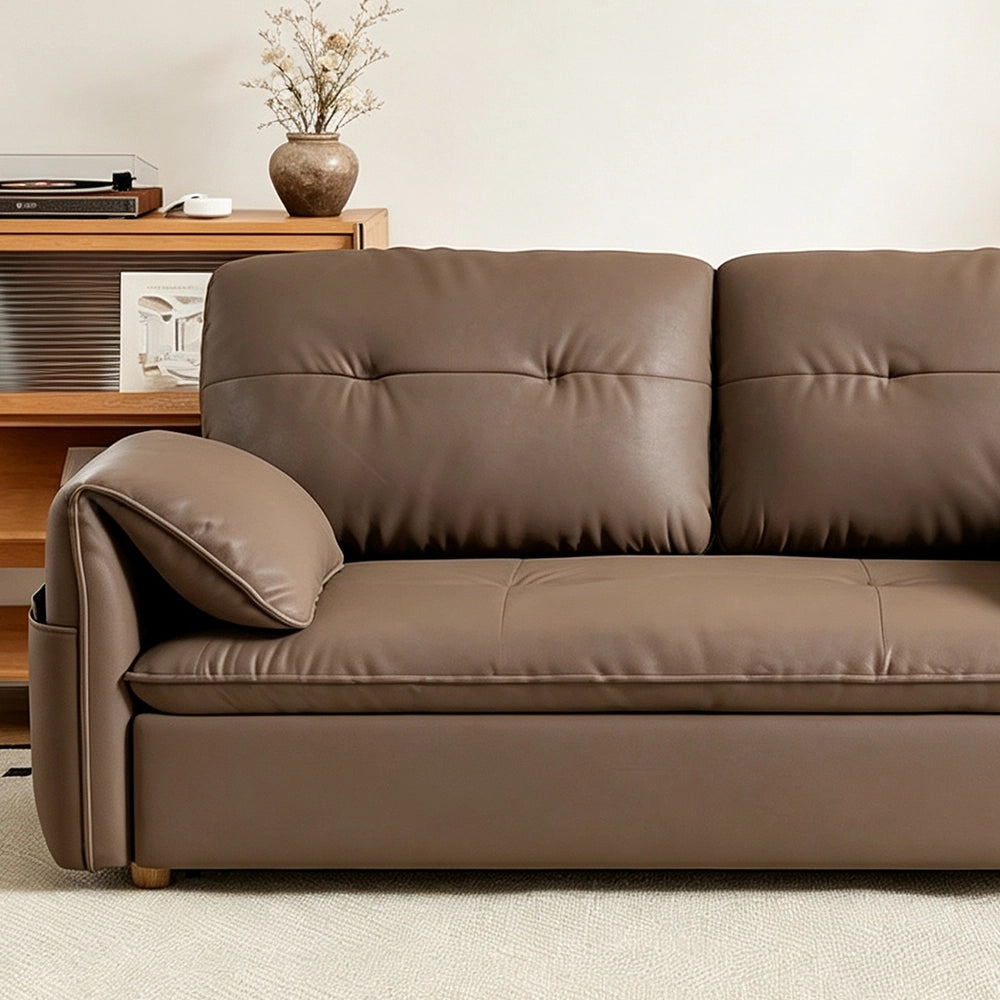 Close-up of the taupe-brown sofa bed's front seat edge and padded arm cushion.