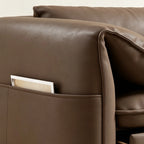 Detail of the taupe-brown sofa bed's outer storage pocket and stitched curved arm.
