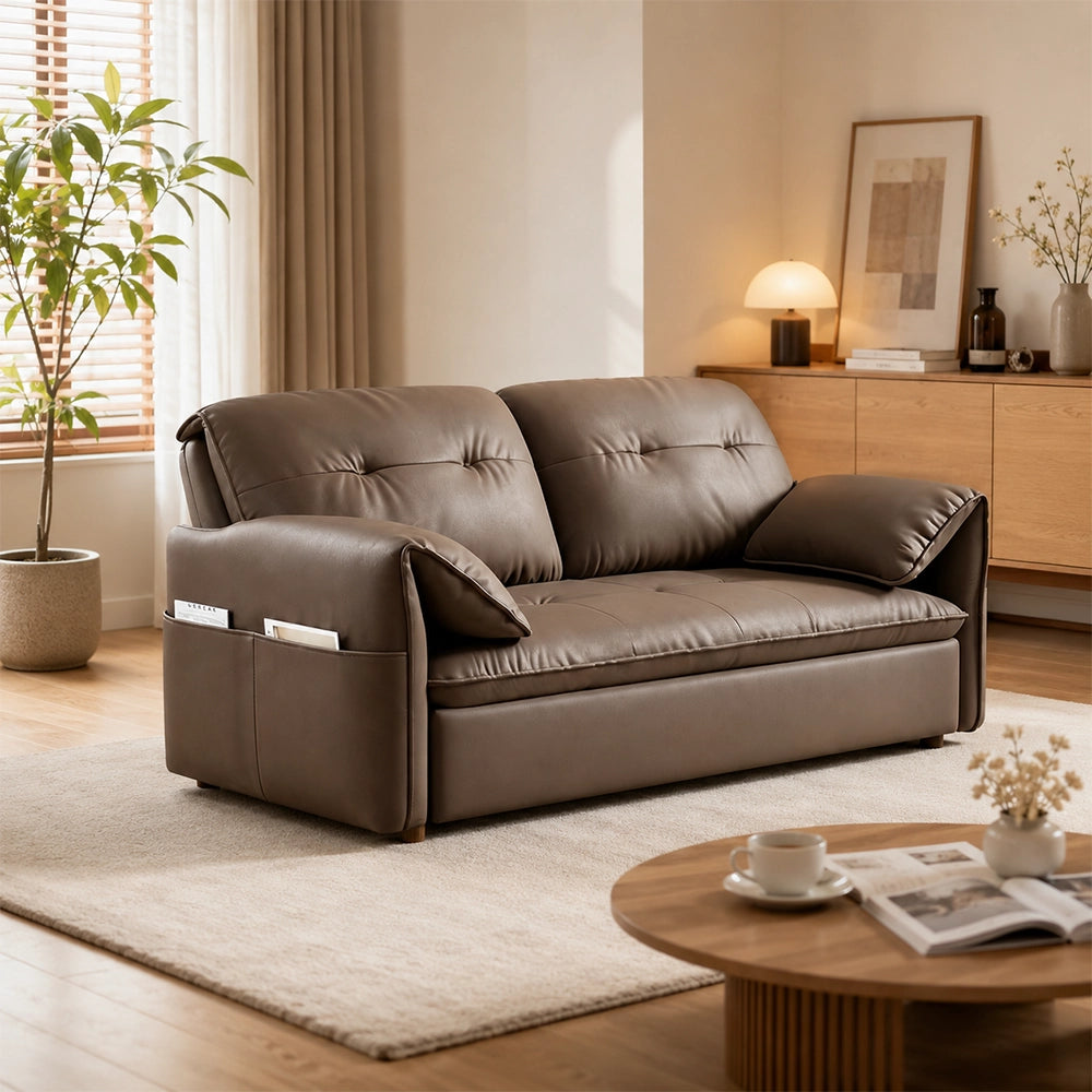 Opposite room view of the taupe-brown sofa bed with padded arm cushions and a side pocket.