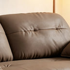 Close-up of the sofa bed's taupe-brown tufted back upholstery.