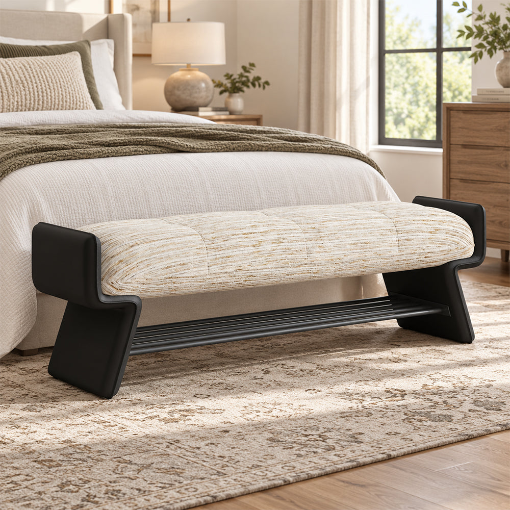 cream upholstered bench with a black frame and open shoe rack at the foot of a bed.