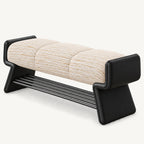 cream textured bench cushion between raised black ends, above angled side supports and a slatted shoe rack.