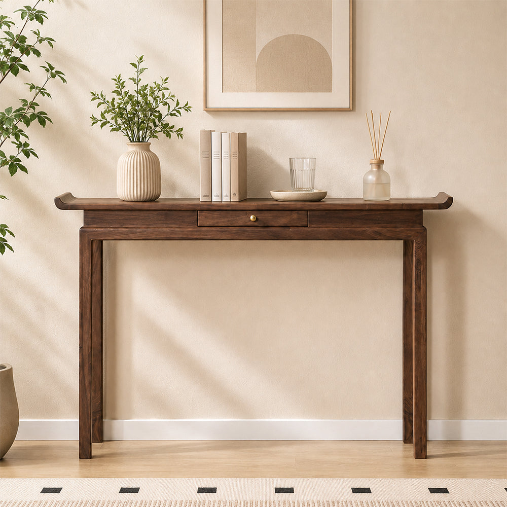 Brown console table with upturned tabletop ends, a small center drawer and four slender legs.
