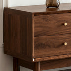 Close-up of the TV cabinet's wood-grain drawer fronts, small round knobs and rounded corner frame.